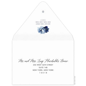 white envelope with the flap up and facing us. two blue watercolor flowers on the flap. Navy script for the name, and block font for the address