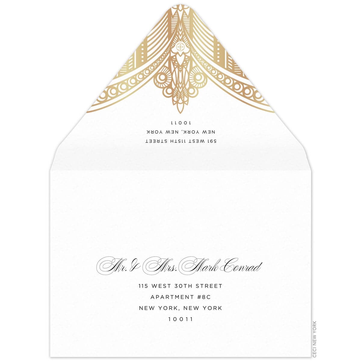 White envelope, gold deco pattern on the tip of the envelope flap. Black san serif return address. Black block and script mailing address on the front of the envelope.