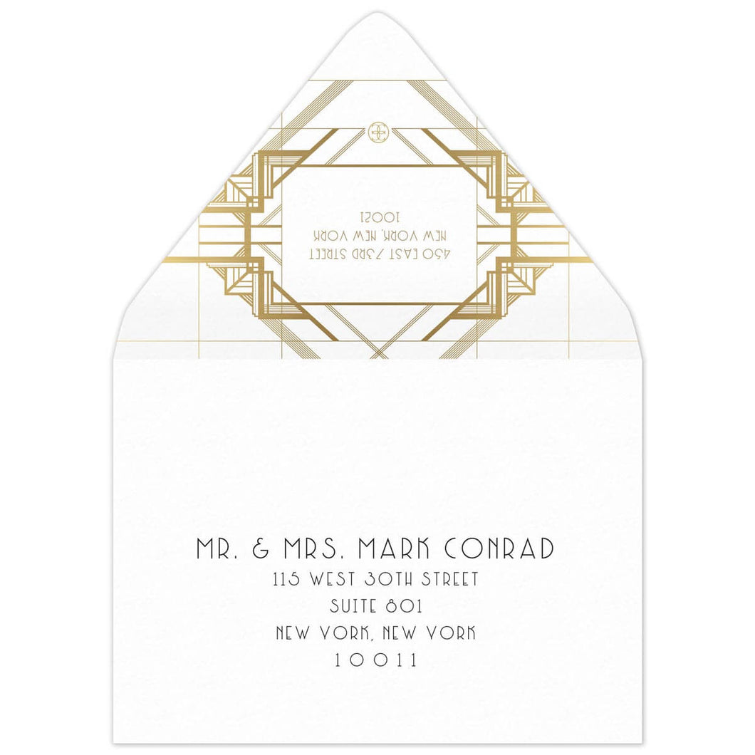 White envelope with gold geometric lines on the back flap. White box in between the lines of a deco font of the reply address. Black deco mailing address centered on the front of the envelope.