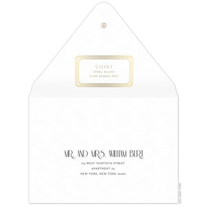 Gold decorative box holding the return address on the back of the envelope flap. Small circle logo on the tip of the flap. Black deco and block copy centered on the front of the envelope.