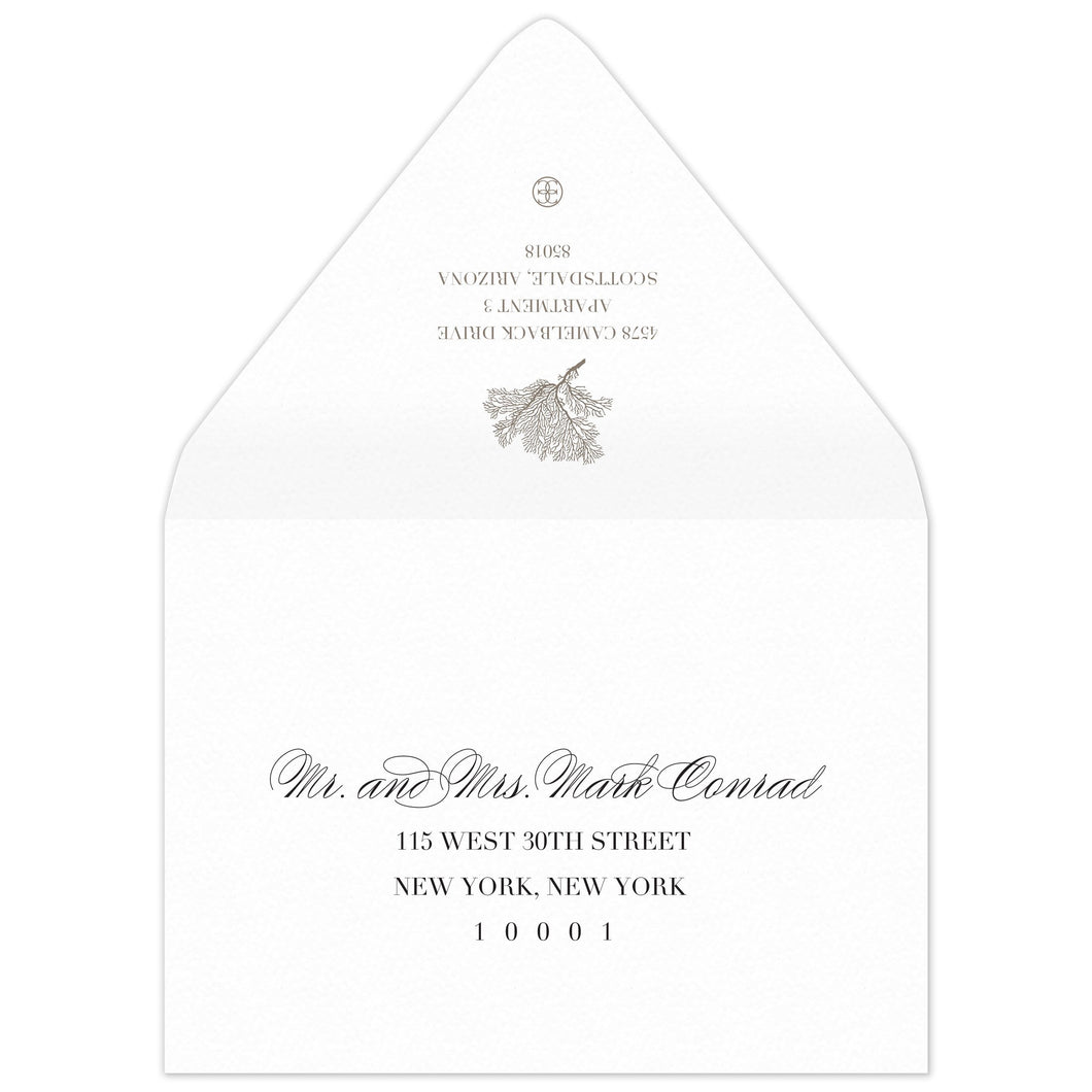 White envelope with a coral motif and block return address on the flap. Scrip and block address on the front.