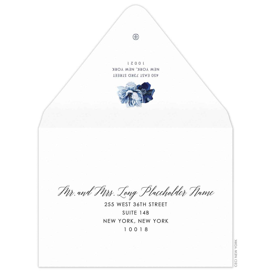 white envelope with the flap up and facing us. two blue watercolor flowers on the flap. Navy script for the name, and block font for the address