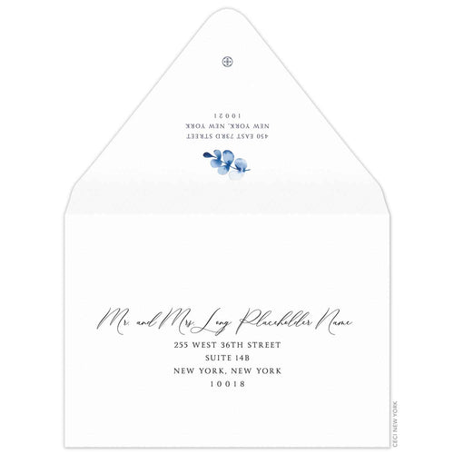 white envelope with blue watercolor leaf embellishment. black script for the name and block font for the address