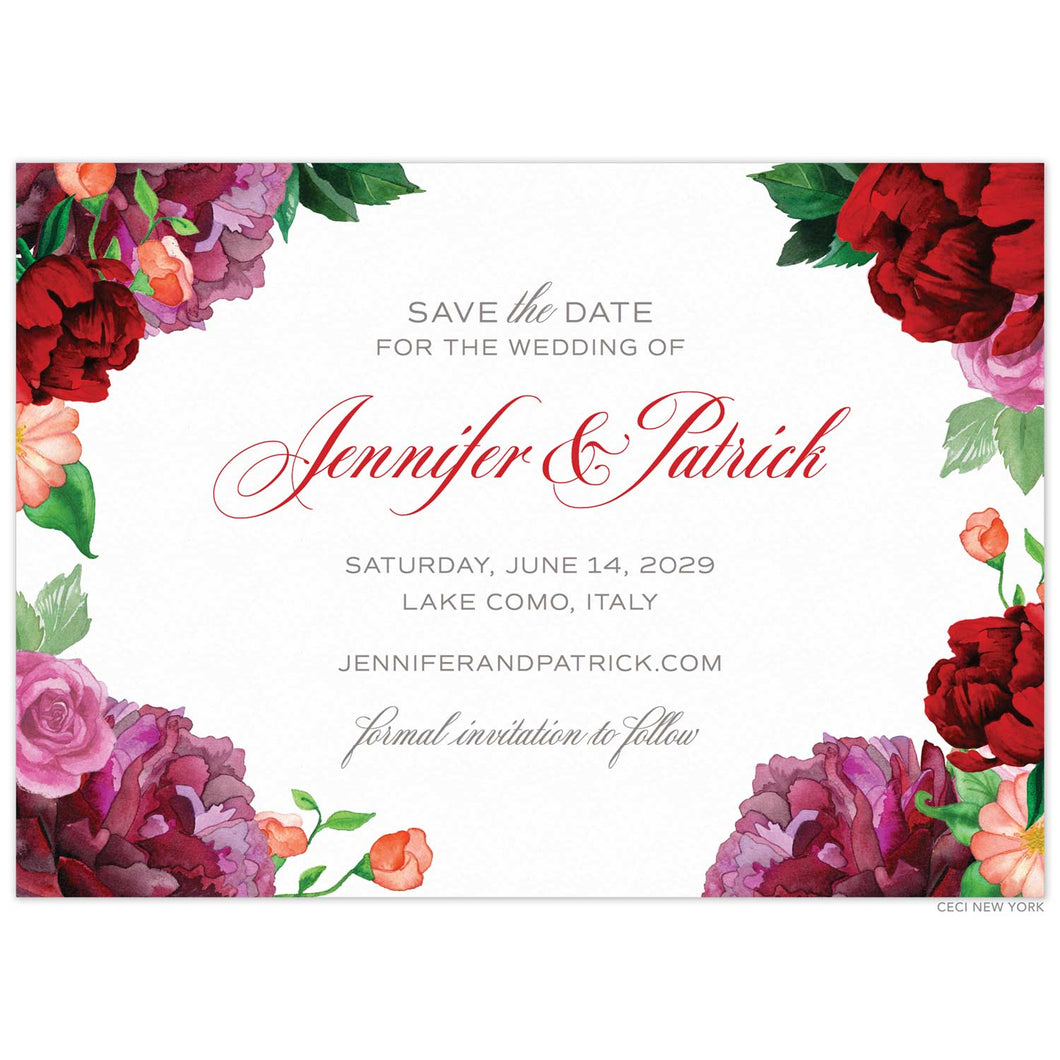 A white save the date with watercolor pink and red colored flowers on the corners and right and left sides. Red script with grey block font centered on the card.