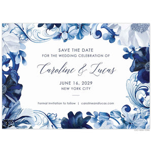 White save the date with watercolor border of scrolls and florals. Centered block and script text in navy.